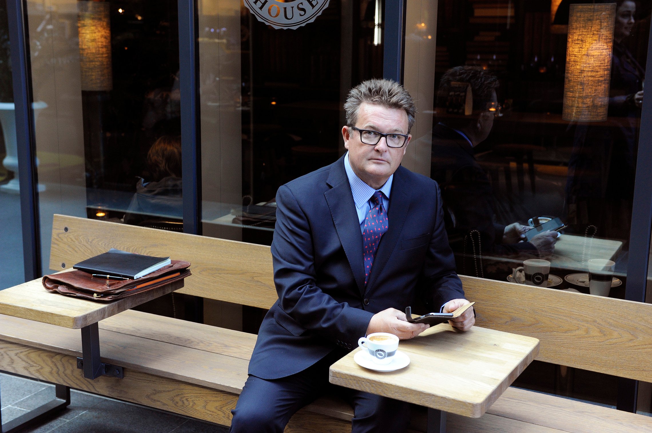 Acting Executive Vice President Gunnar Henriksen sits at a table next to a coffee shop