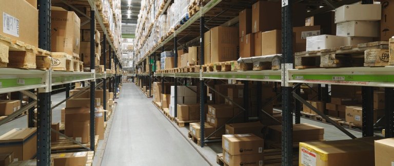 Aisle in a warehouse between two rows of shelves