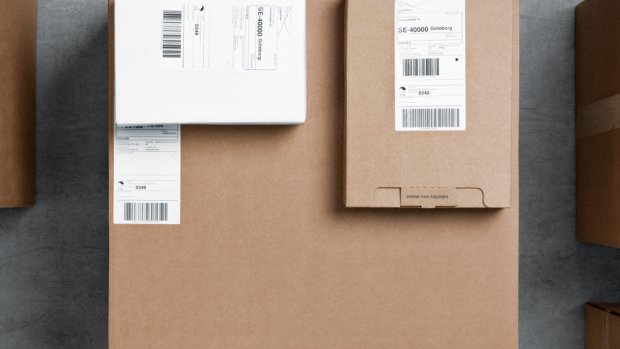 Two smaller cardboard parcels lying on top of a bigger parcel