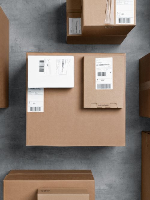 Two smaller cardboard parcels lying on top of a bigger parcel